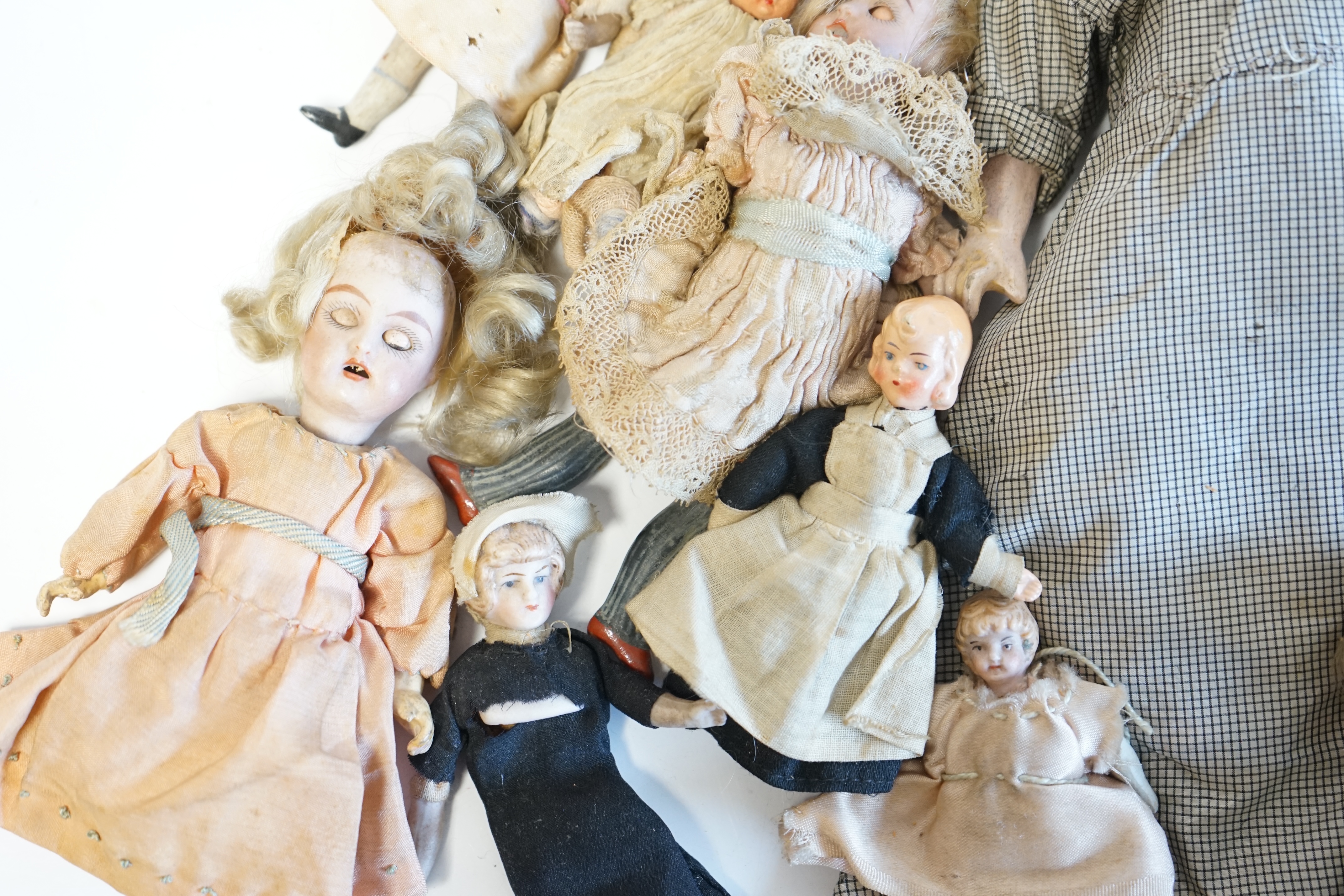 Eleven doll's house dolls, 19th and early 20th century, including two Kammer & Reinhardt bisque jointed dolls and a wax over composition doll in original clothes (12). Condition - fair